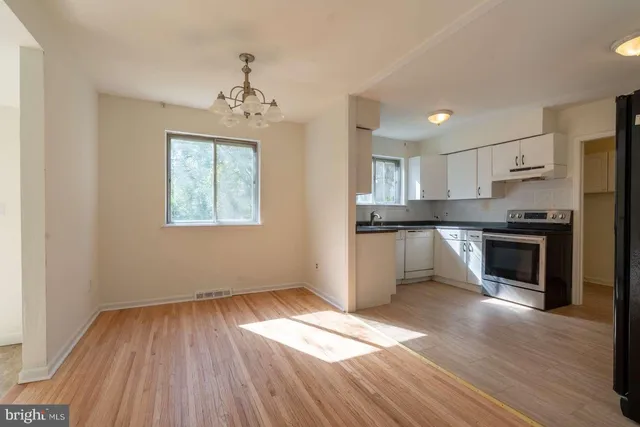 a kitchen with granite countertop wooden floors stainless steel appliances and sink