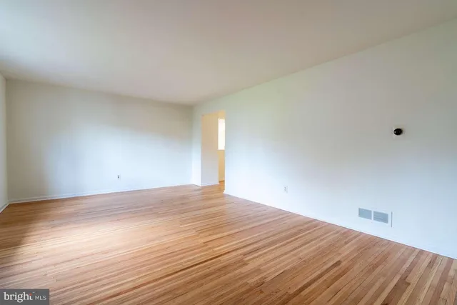 a view of an empty room and wooden floor