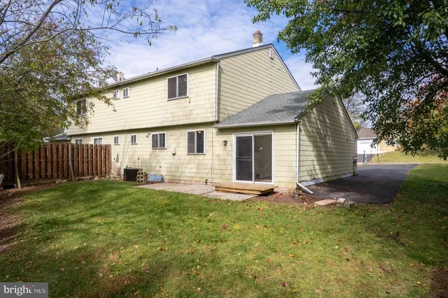 a view of a house with backyard and a tree