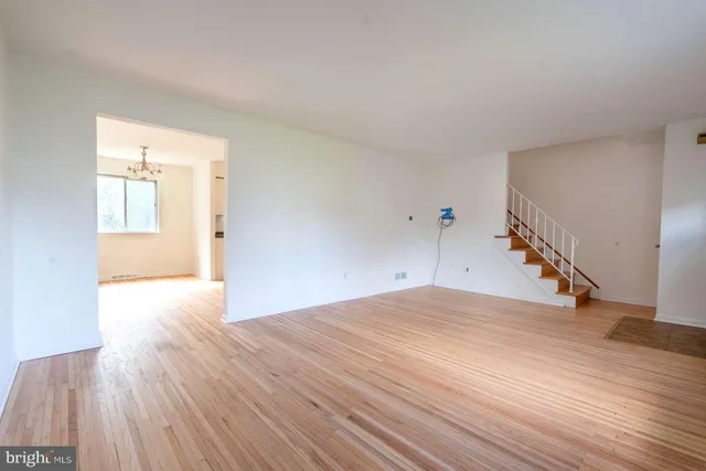 a view of a livingroom with wooden floor and stairs