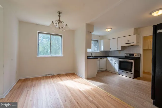 a kitchen with granite countertop wooden floors stainless steel appliances and sink