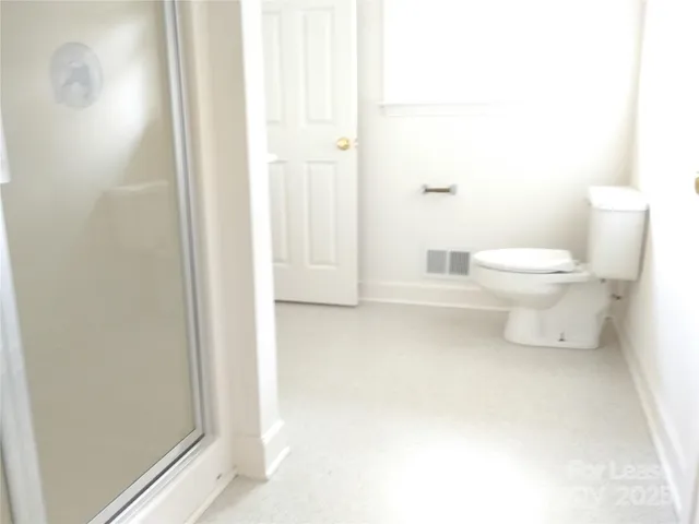 a bathroom with a toilet and a shower