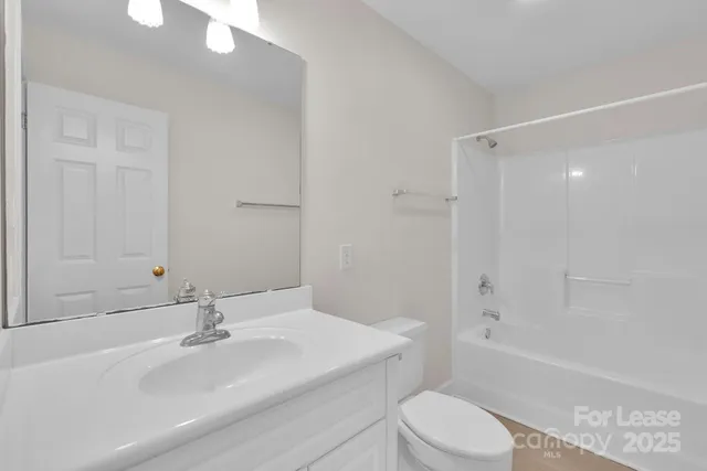 a bathroom with a sink toilet vanity and shower