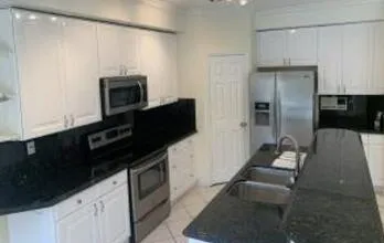 a kitchen with a refrigerator and a stove top oven