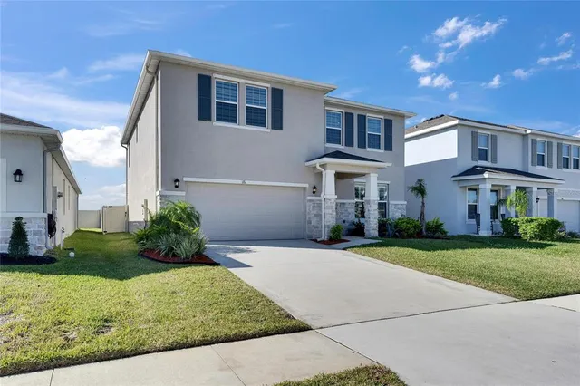 a front view of a house with a yard and garage