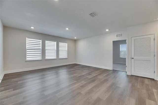 a view of an empty room with wooden floor