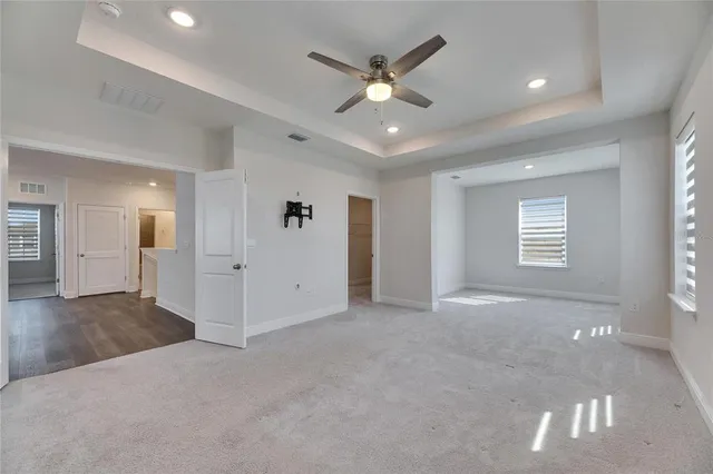 an empty room with a ceiling fan and a bathroom