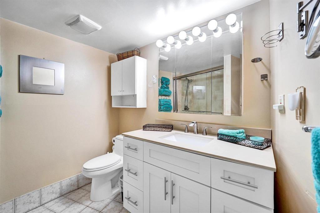 100 Golden Isles Drive, Unit 815 Hallandale Beach, FL 33009 - Photo 11 of 42 a bathroom with a toilet sink and mirror
