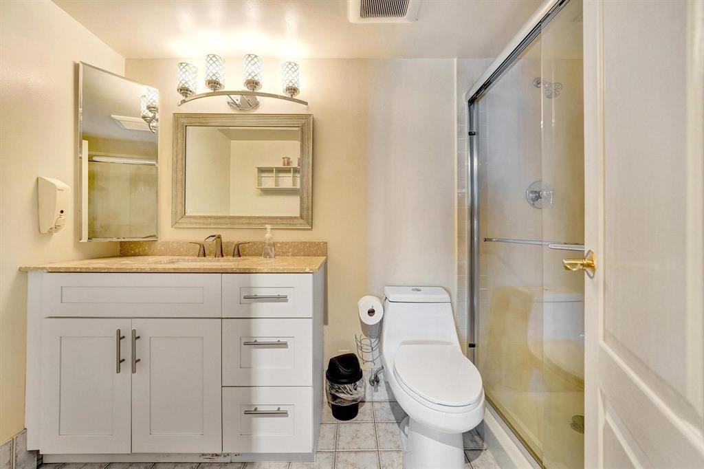 100 Golden Isles Drive, Unit 815 Hallandale Beach, FL 33009 - Photo 15 of 42 a bathroom with a granite countertop toilet sink and mirror