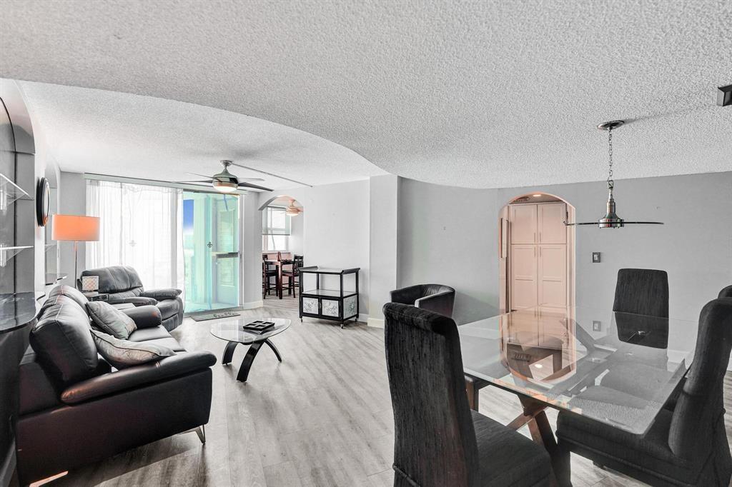 100 Golden Isles Drive, Unit 815 Hallandale Beach, FL 33009 - Photo 3 of 42 a living room with furniture a wooden floor and a large window