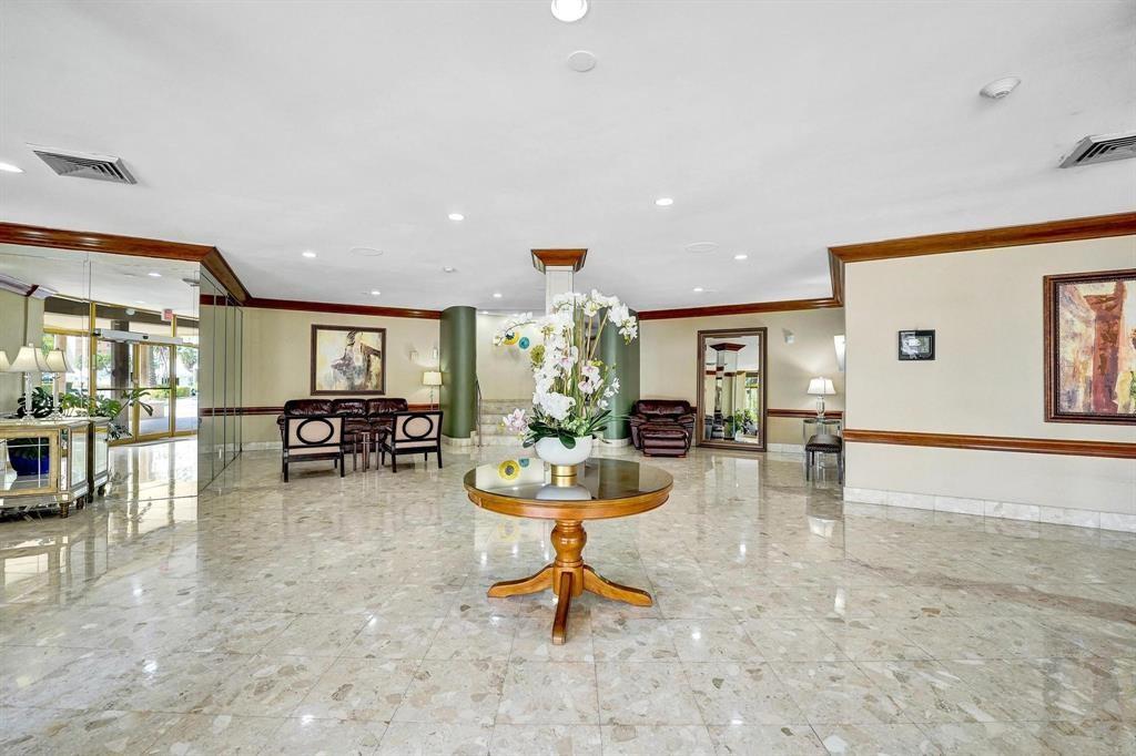 100 Golden Isles Drive, Unit 815 Hallandale Beach, FL 33009 - Photo 32 of 42 a living room with furniture and a dining table with kitchen view