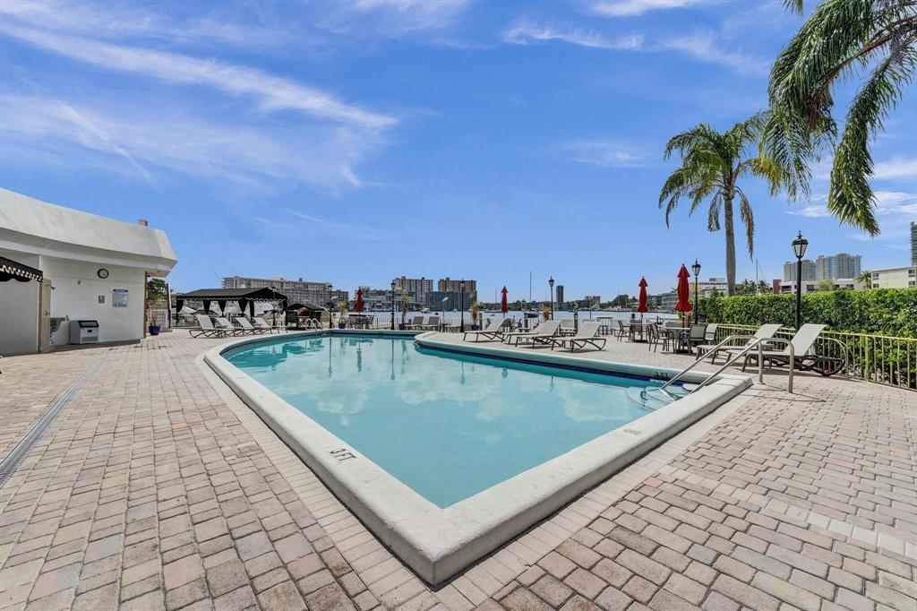 100 Golden Isles Drive, Unit 815 Hallandale Beach, FL 33009 - Photo 38 of 42 a view of a swimming pool and lounge chairs