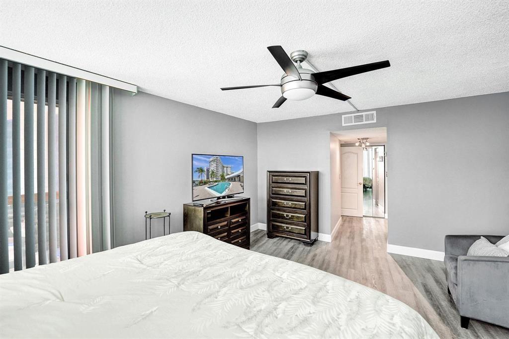 100 Golden Isles Drive, Unit 815 Hallandale Beach, FL 33009 - Photo 8 of 42 a bedroom with a bed and a flat screen tv