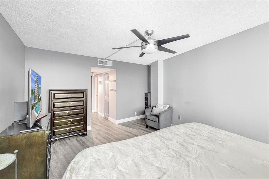 100 Golden Isles Drive, Unit 815 Hallandale Beach, FL 33009 - Photo 9 of 42 a bedroom with a bed and a chandelier