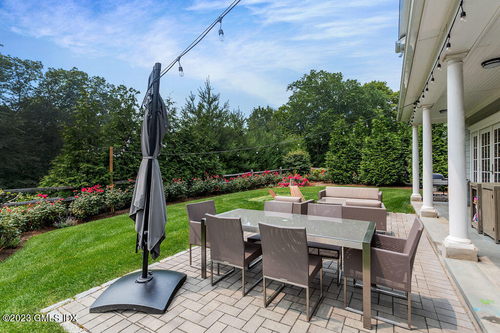 552 River Road Cos Cob, CT 06807 - Photo 27 of 35 a view of a patio with a table chairs and a garden