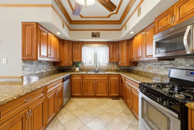 a kitchen with stainless steel appliances granite countertop a stove sink and cabinets