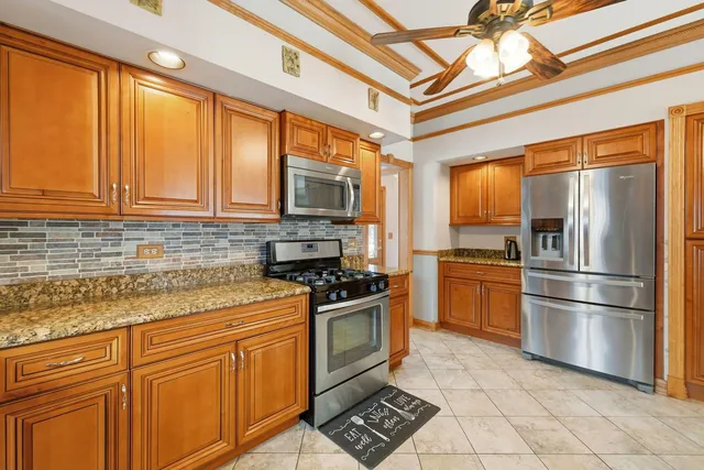 a kitchen with stainless steel appliances granite countertop a refrigerator a sink a stove and cabinets