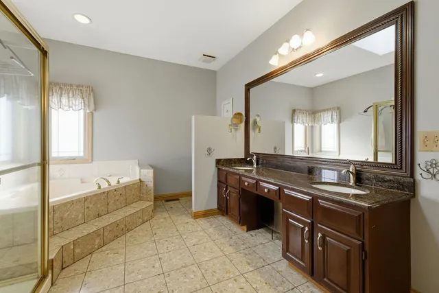 a large bathroom with a tub sink and mirror