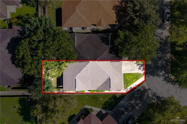 an aerial view of a house with a yard and trees