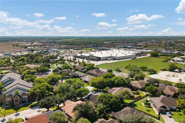 an aerial view of a city with lots of residential buildings ocean and mountain view in back