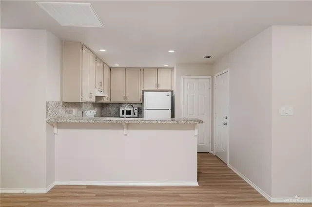 a view of kitchen with stainless steel appliances granite countertop refrigerator sink and cabinets
