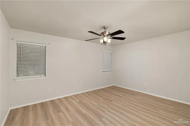 a view of a room with a large window and wooden floor