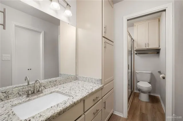 a bathroom with a granite countertop sink toilet and shower