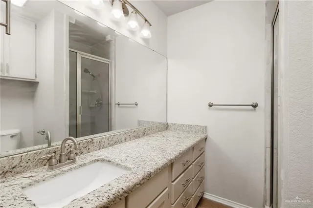 a bathroom with a granite countertop sink and a mirror