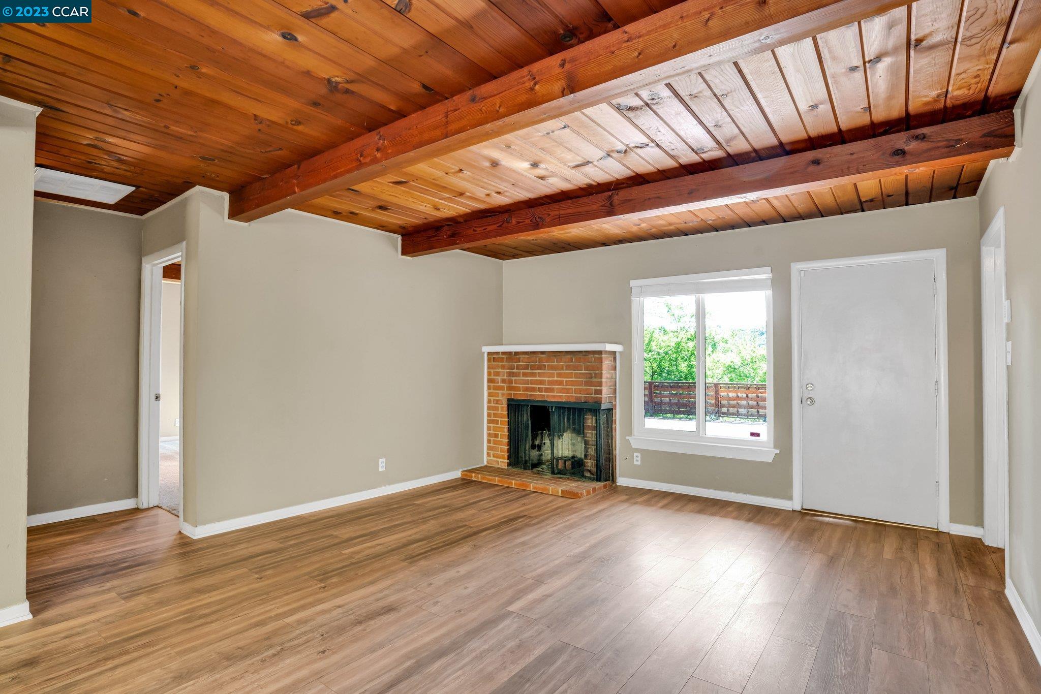 928 Janet Lane Lafayette, CA 94549 - Photo 14 of 33 a view of an empty room with wooden floor fireplace and a window