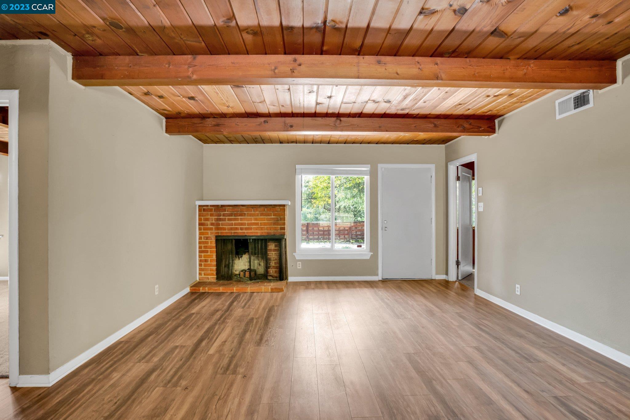 928 Janet Lane Lafayette, CA 94549 - Photo 15 of 33 a view of an empty room with wooden floor fireplace and a window