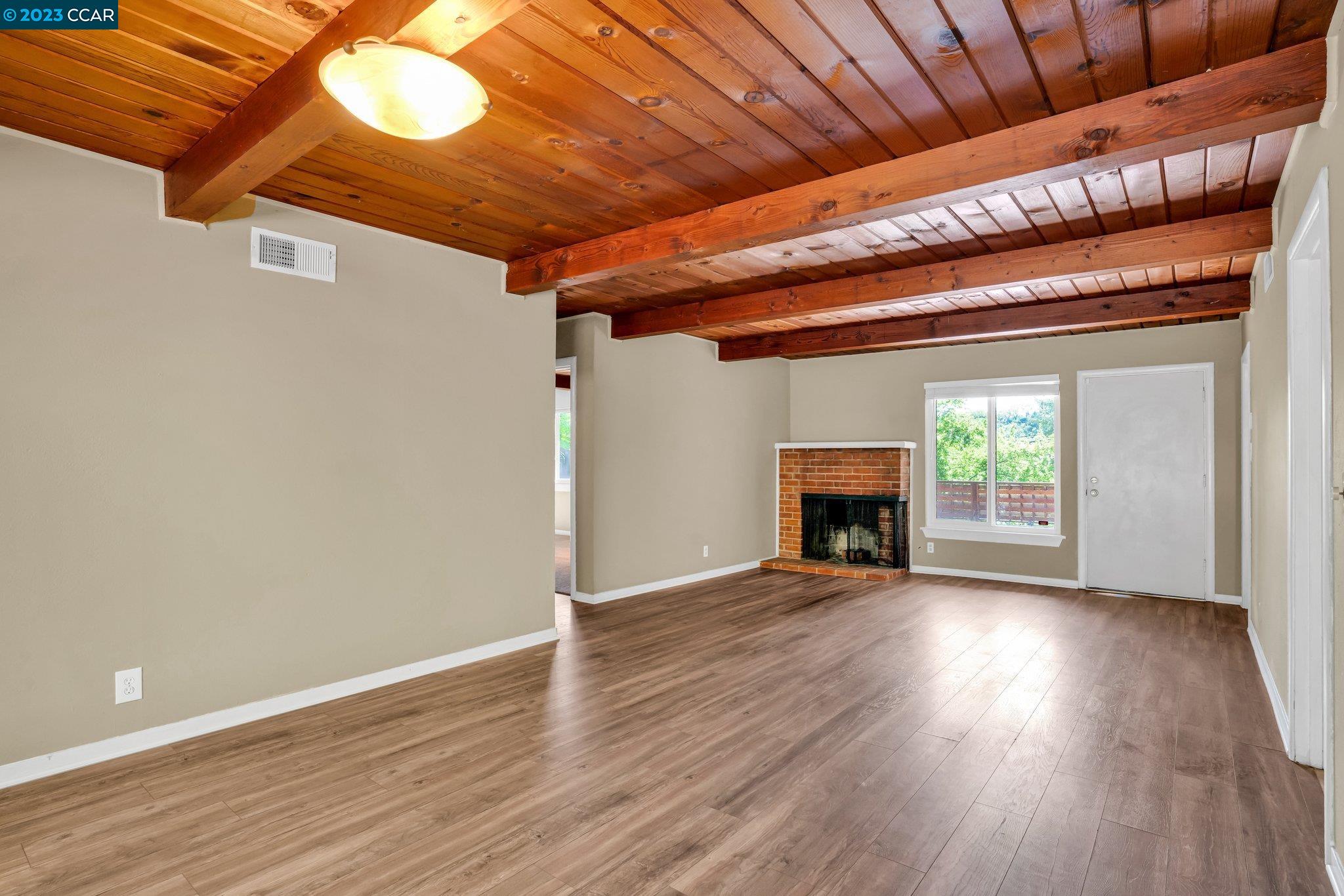 928 Janet Lane Lafayette, CA 94549 - Photo 6 of 33 a view of an empty room with wooden floor fireplace and a window