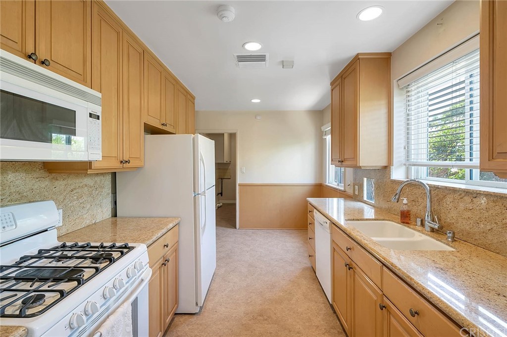 4906 Van Noord Avenue Sherman Oaks, CA 91423 - Photo 11 of 39 a kitchen with stainless steel appliances a sink a stove a refrigerator cabinets and a window