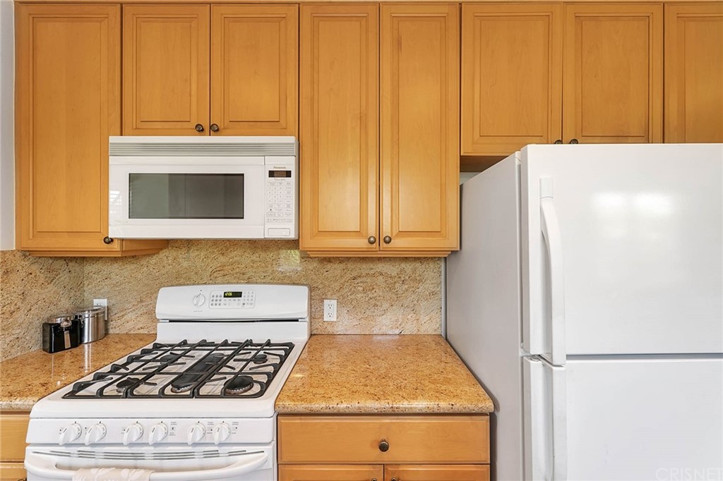 4906 Van Noord Avenue Sherman Oaks, CA 91423 - Photo 15 of 39 a kitchen with granite countertop white cabinets and stainless steel appliances