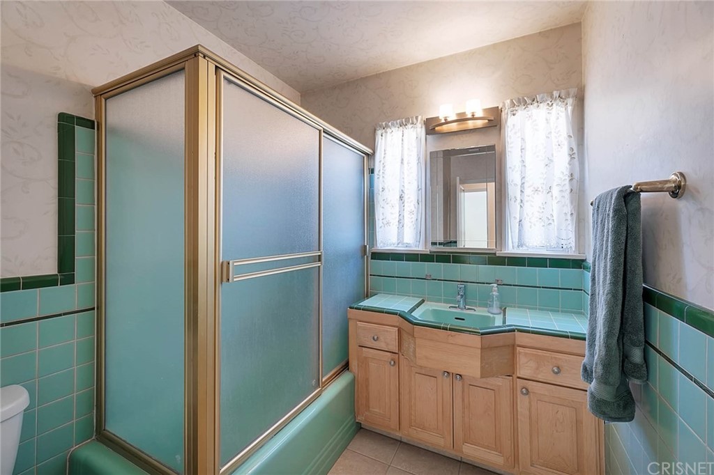 4906 Van Noord Avenue Sherman Oaks, CA 91423 - Photo 27 of 39 a bathroom with a double vanity sink and mirror