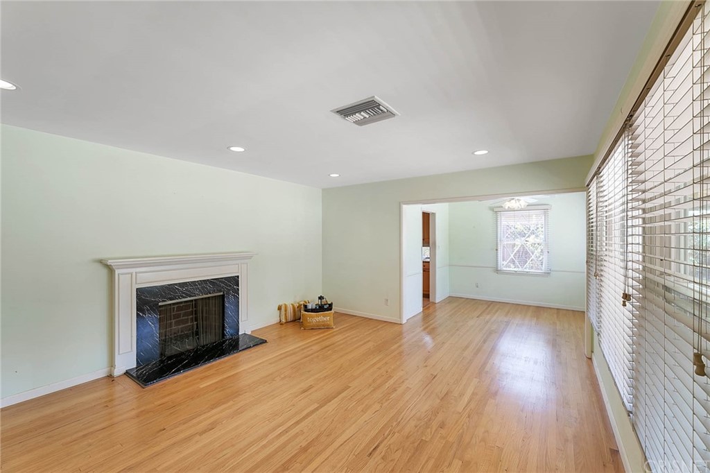 4906 Van Noord Avenue Sherman Oaks, CA 91423 - Photo 3 of 39 an empty room with wooden floor fireplace and windows