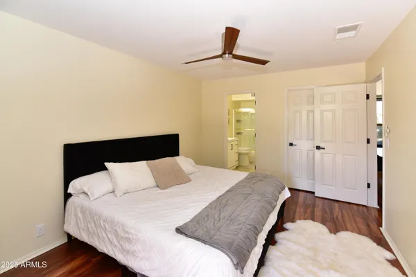 a bedroom with a bed and painting on the wall