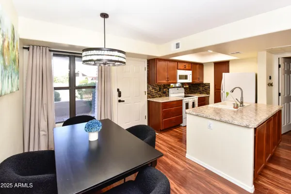 a kitchen with stainless steel appliances granite countertop a stove a sink and a refrigerator