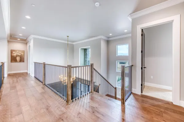 a view of a hallway with wooden floor and stairs