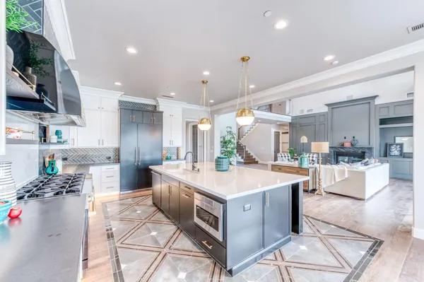 a large kitchen with stainless steel appliances a stove a sink dishwasher and a dining table with the living room view