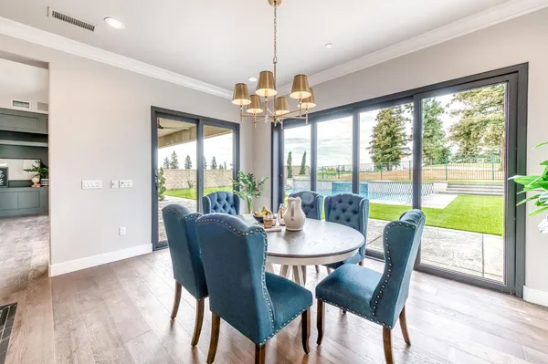 a dining room with furniture a chandelier and wooden floor