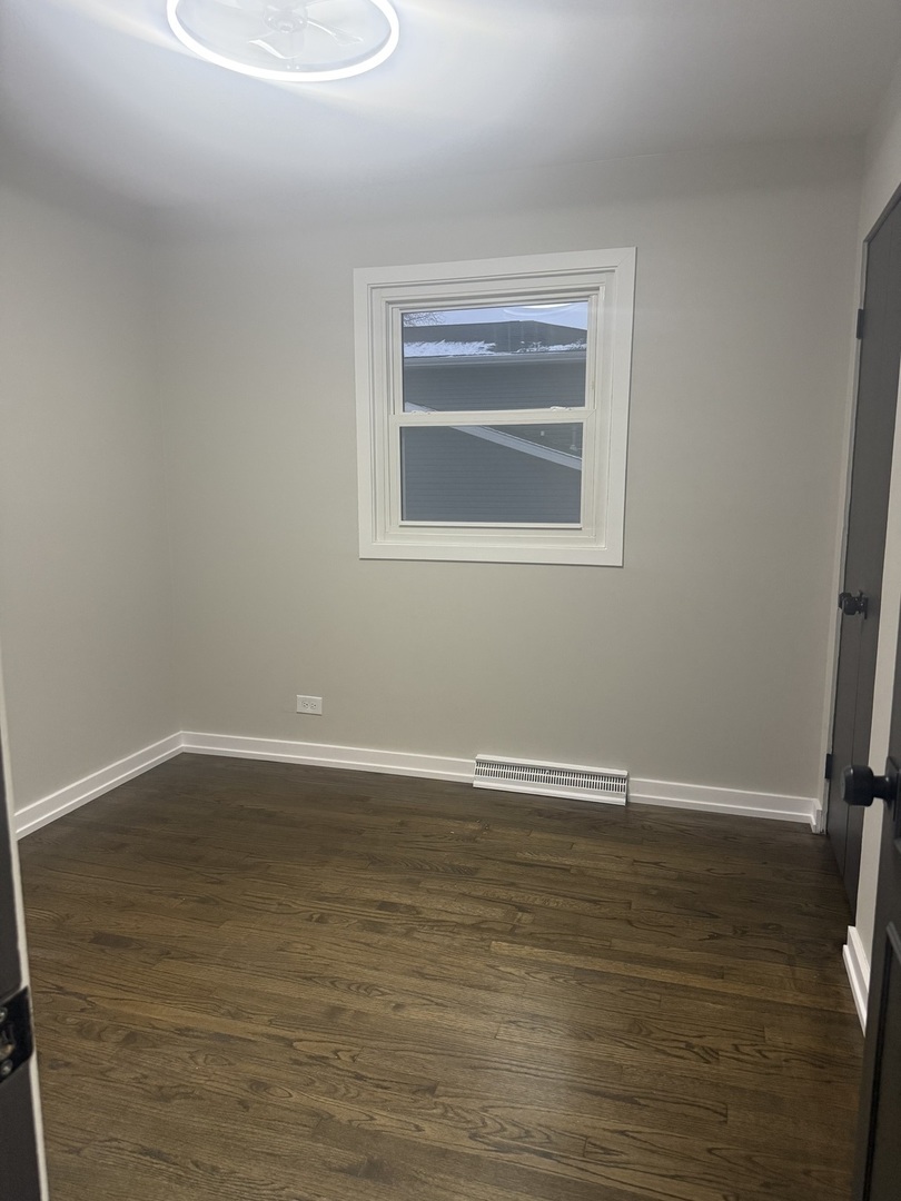 126 Rosedale Court Bloomingdale, IL 60108 - Photo 15 of 26 a view of an empty room with wooden floor and a window