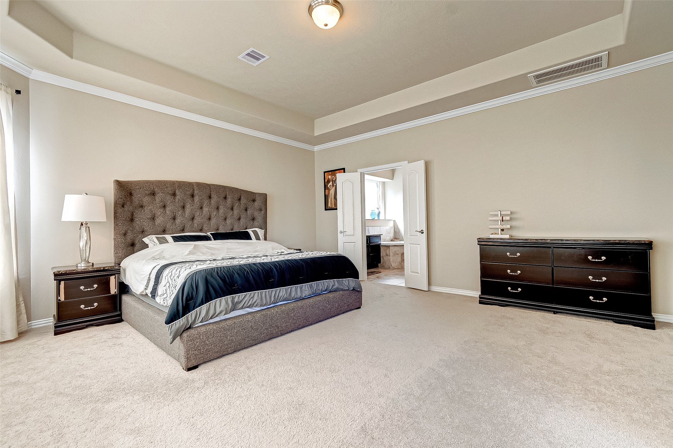 907 River Delta Lane Rosenberg, TX 77469 - Photo 27 of 49 a bedroom with a bed and a chandelier