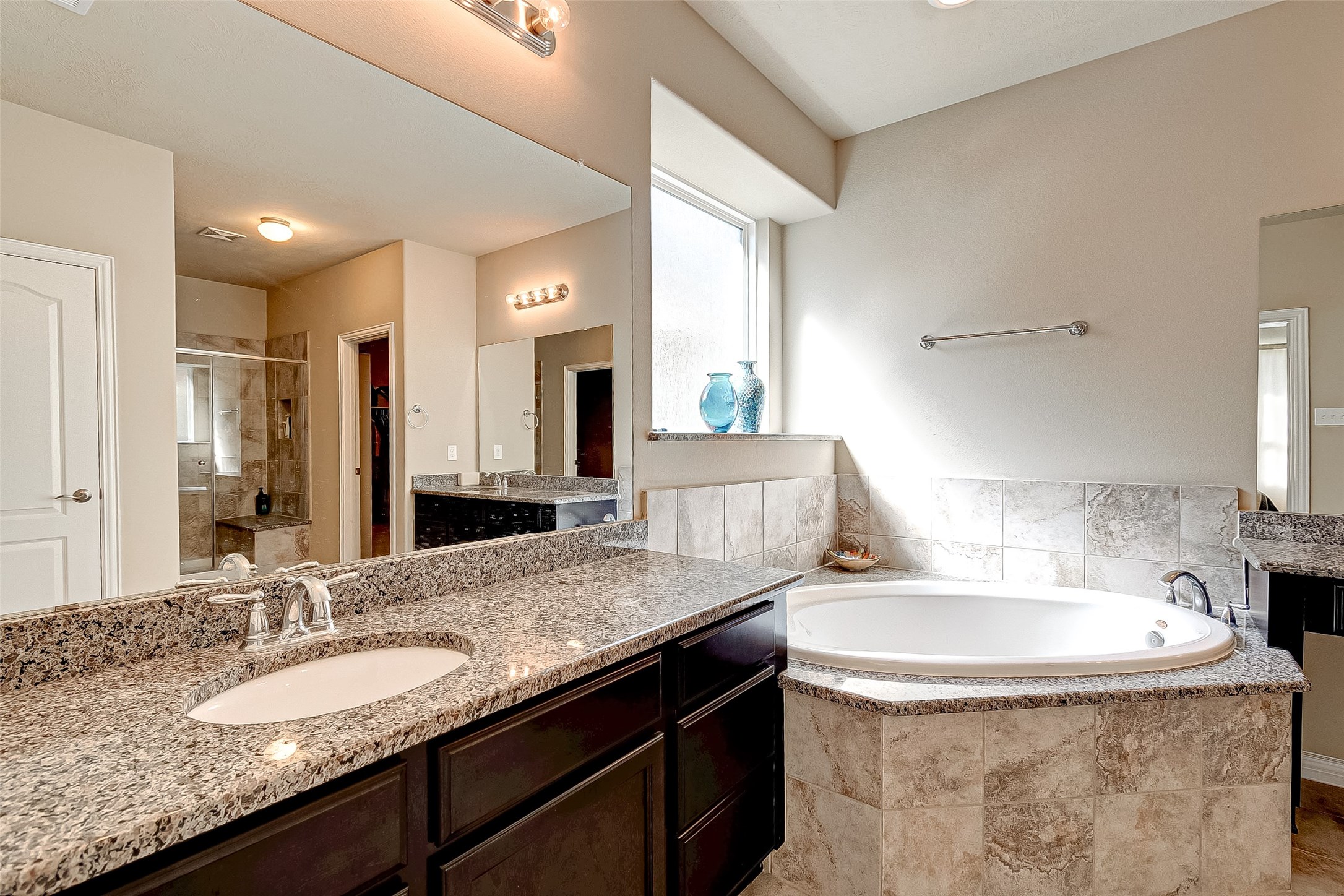 907 River Delta Lane Rosenberg, TX 77469 - Photo 29 of 49 a bathroom with a granite countertop sink a mirror and a bathtub