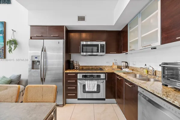 a kitchen with stainless steel appliances granite countertop a stove a sink and a microwave