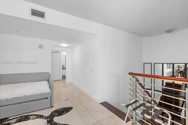 a view of a bedroom with furniture and book shelf