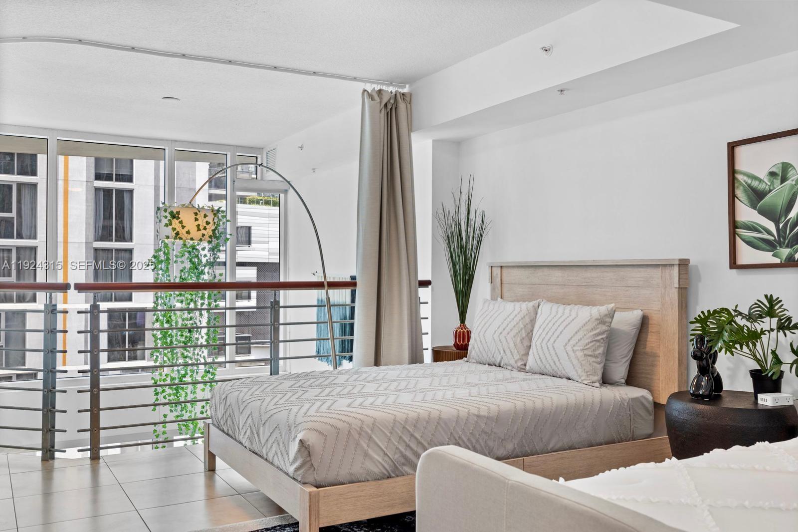 41 Southeast 5th Street, Unit 510 Miami, FL 33131 - Photo 22 of 38 a bedroom with a large bed and a potted plant