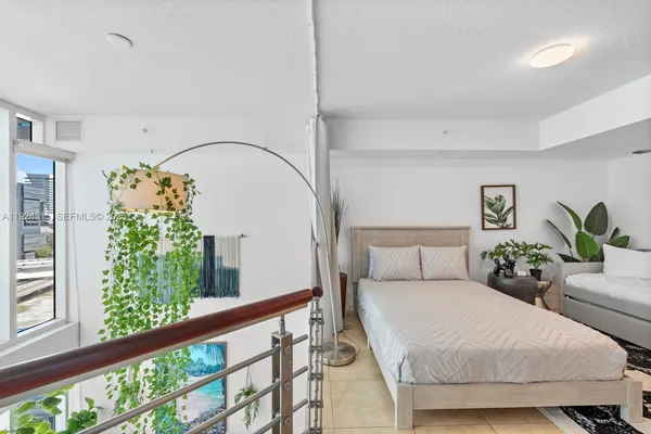 a bedroom with a bed and a potted plant
