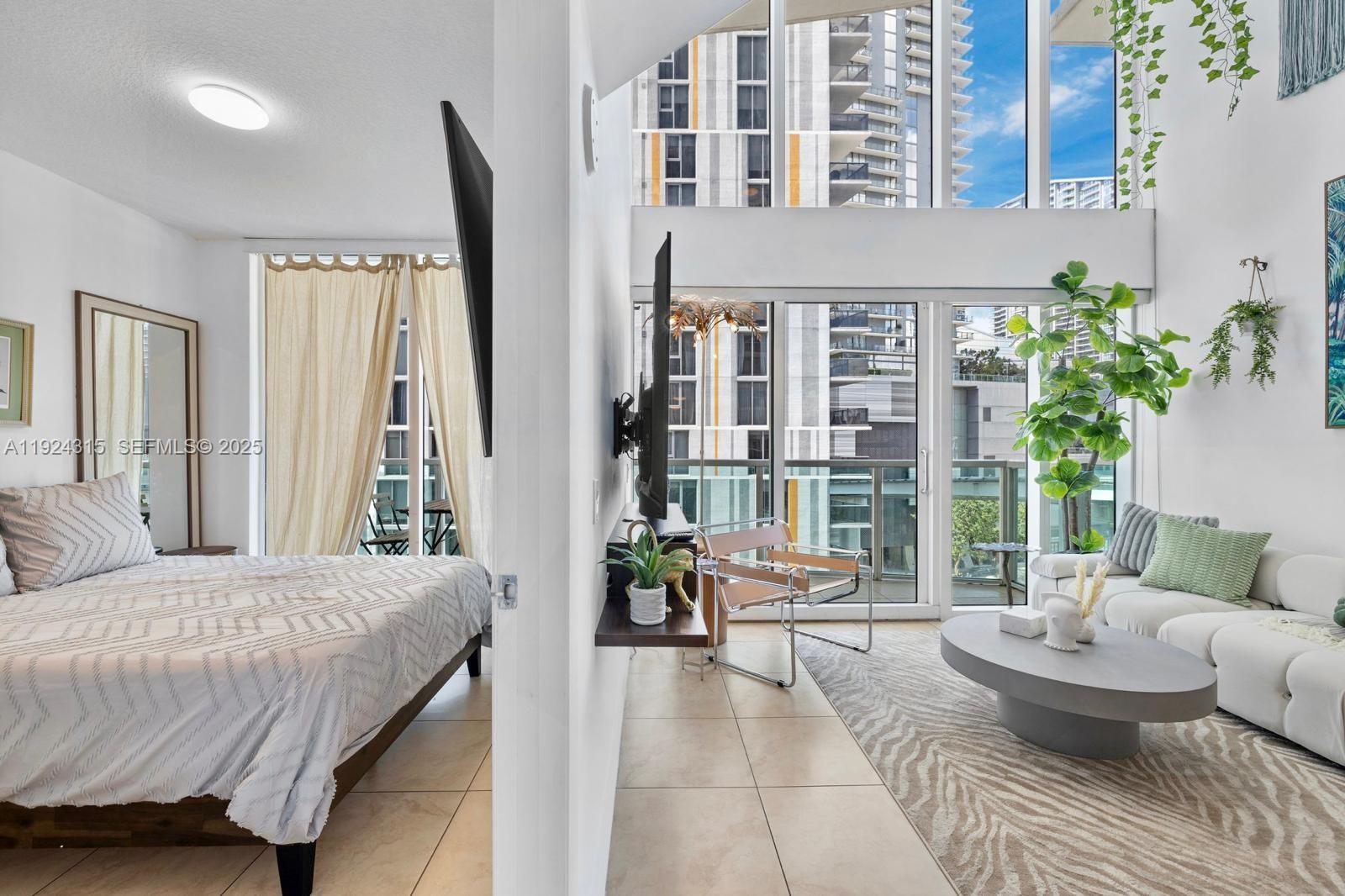 41 Southeast 5th Street, Unit 510 Miami, FL 33131 - Photo 25 of 38 a spacious bedroom with a large bed and a potted plant