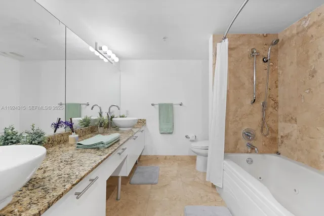 a bathroom with a granite countertop tub sink and mirror