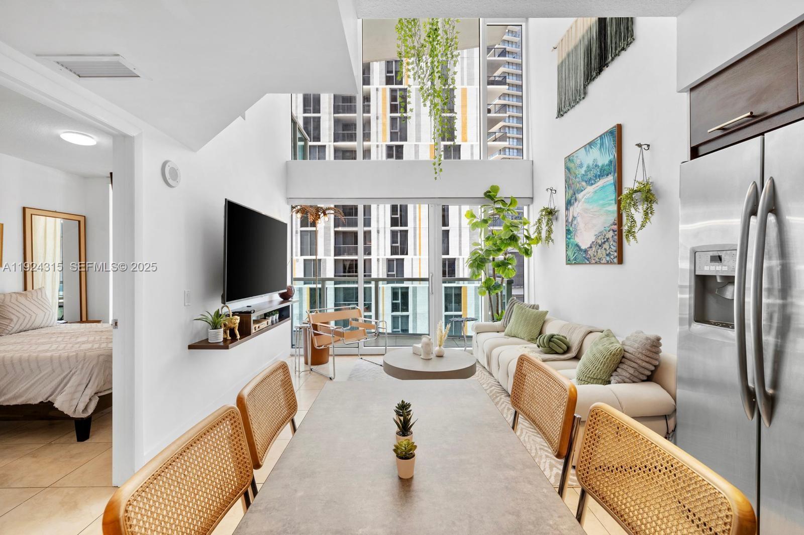 41 Southeast 5th Street, Unit 510 Miami, FL 33131 - Photo 9 of 38 a living room with furniture and a flat screen tv